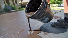 3584 Person pouring a bucket of coal tar on a driveway