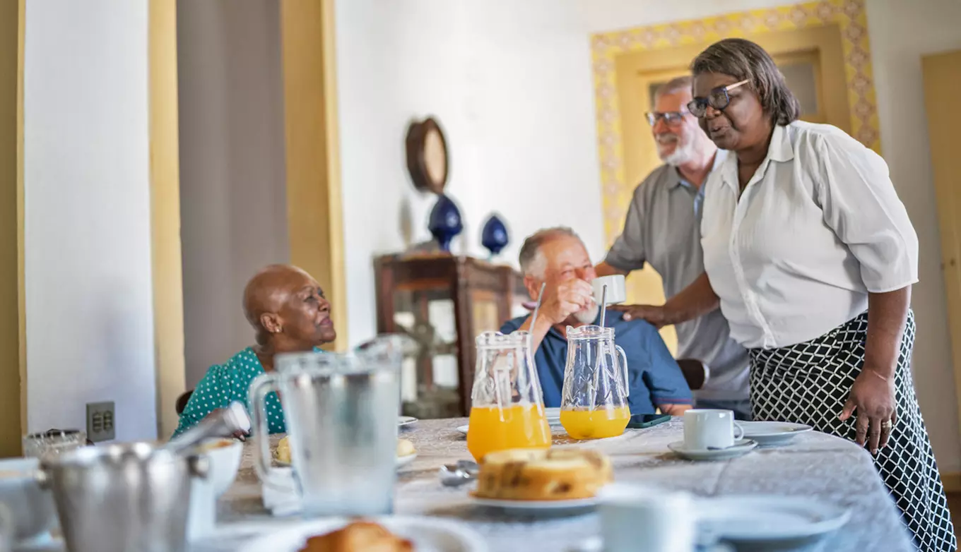 Folks at mealtime, photo showing hostess and visitors at table