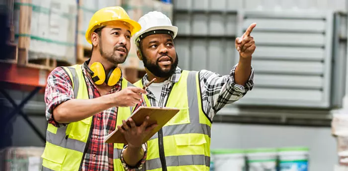 Inspectors conferring over safety codes, one pointing out something to the other