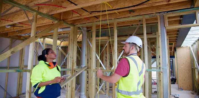 Inspection of residential home being built, inspector and builder check for code compliancy