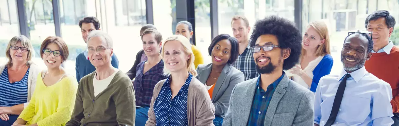 A multicultural group of people listening to a presentation