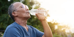 man drinking water on an extremely hot day